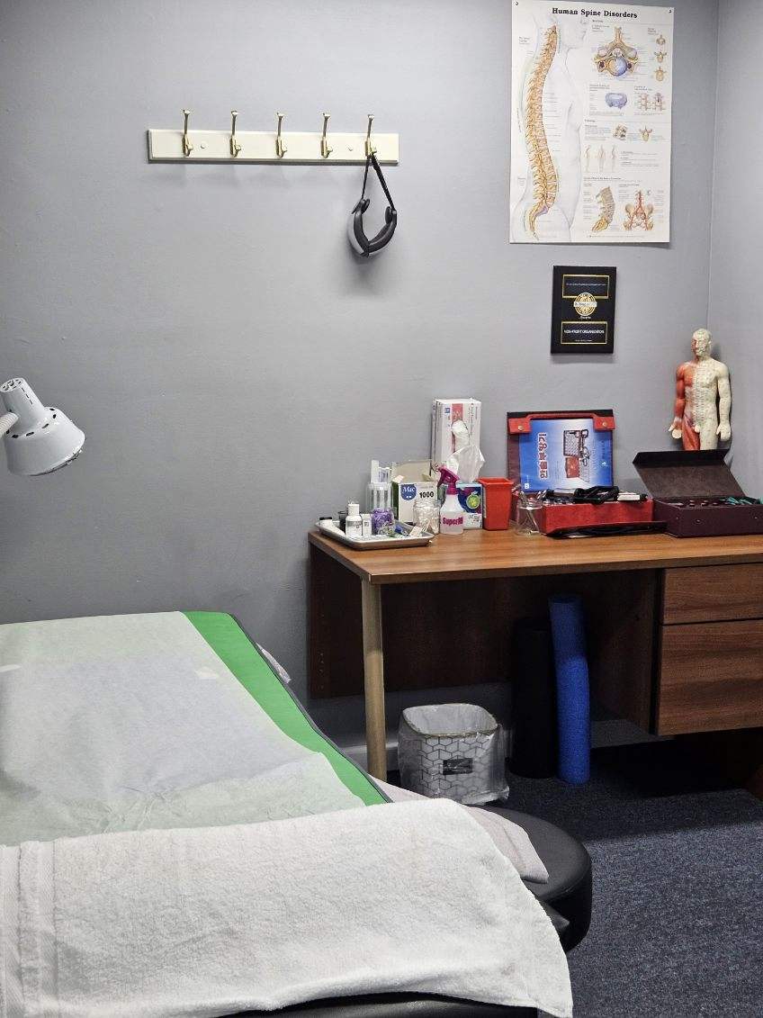 Private acupuncture treatment room with a prepared treatment table