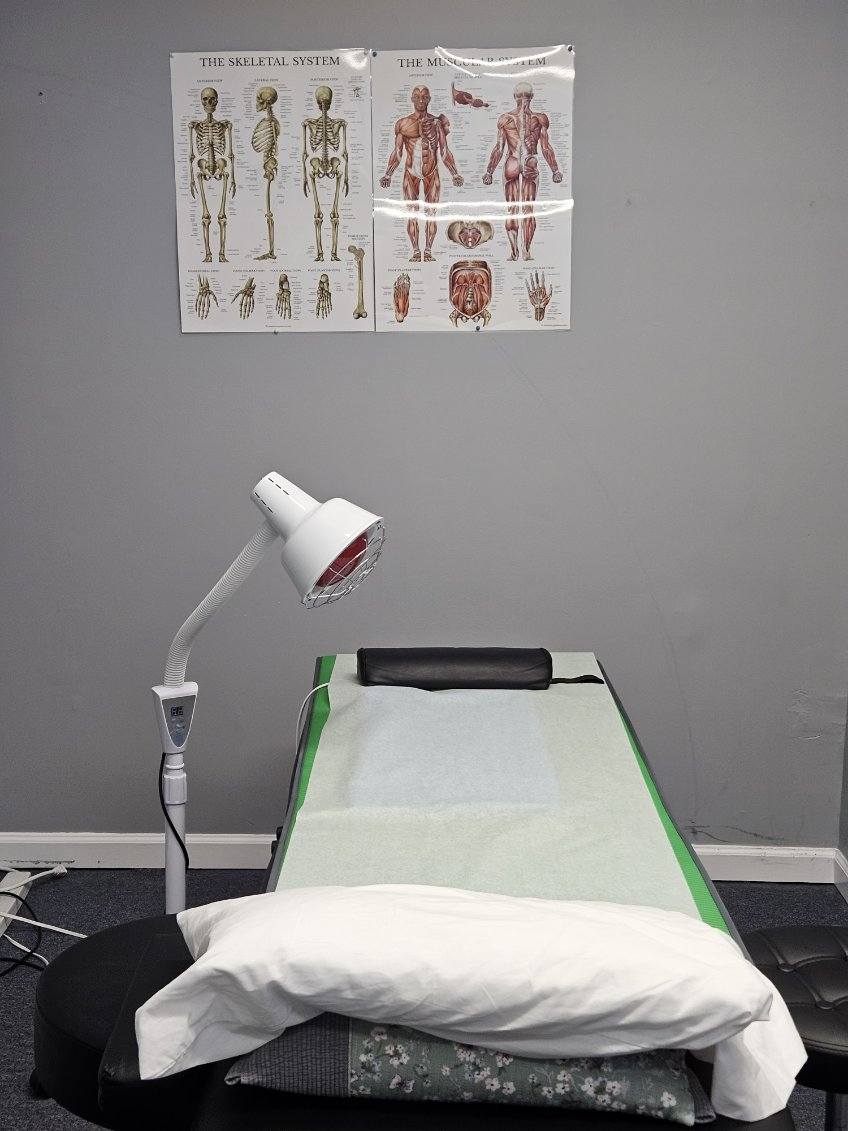 Clean acupuncture room with treatment table and clinical equipment