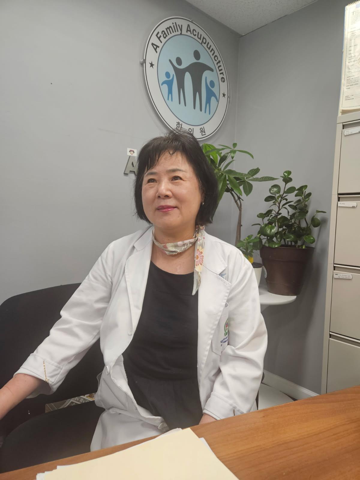 Dr. Marybeth Hong seated in her Ellicott City acupuncture clinic